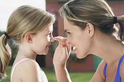 mom applying sunscreen to child's nose